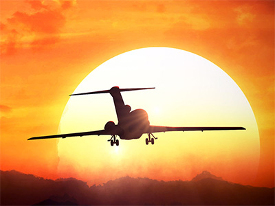 An aeroplane taking off into the sunset